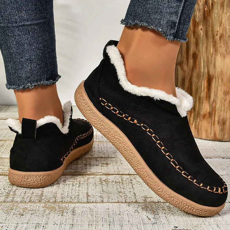 Black plush lined slip-on ankle boots with stitched moc toe, front view
