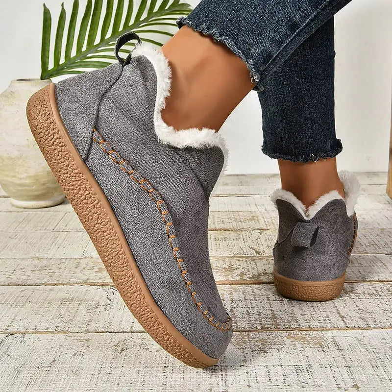 Gray plush lined slip-on ankle boots with stitched moc toe, front view