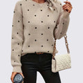 Woman in a beige crew neck sweater with small black polka dots and black jeans