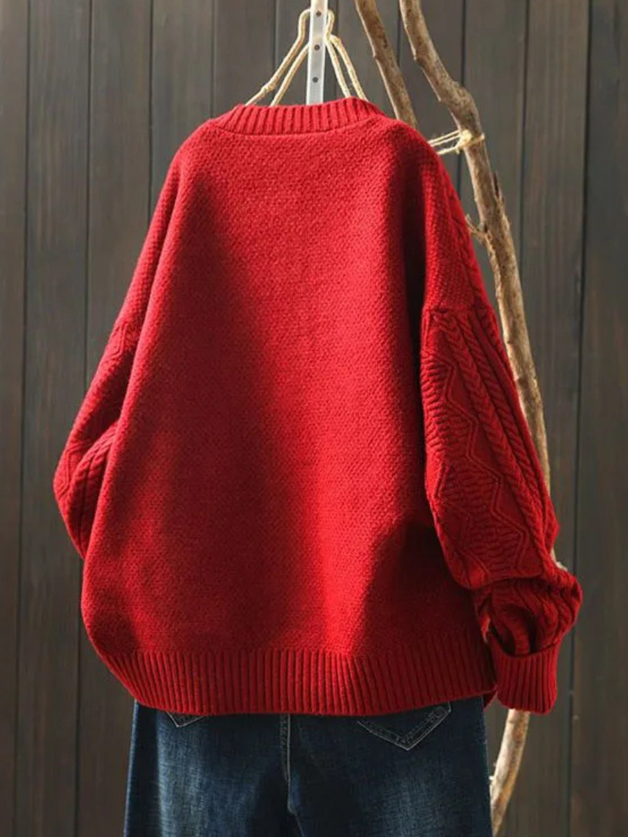 Back view of a red oversized cable knit cardigan on a hanger