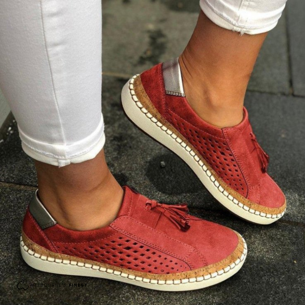 Red slip on sneakers with perforated panels and a tassel