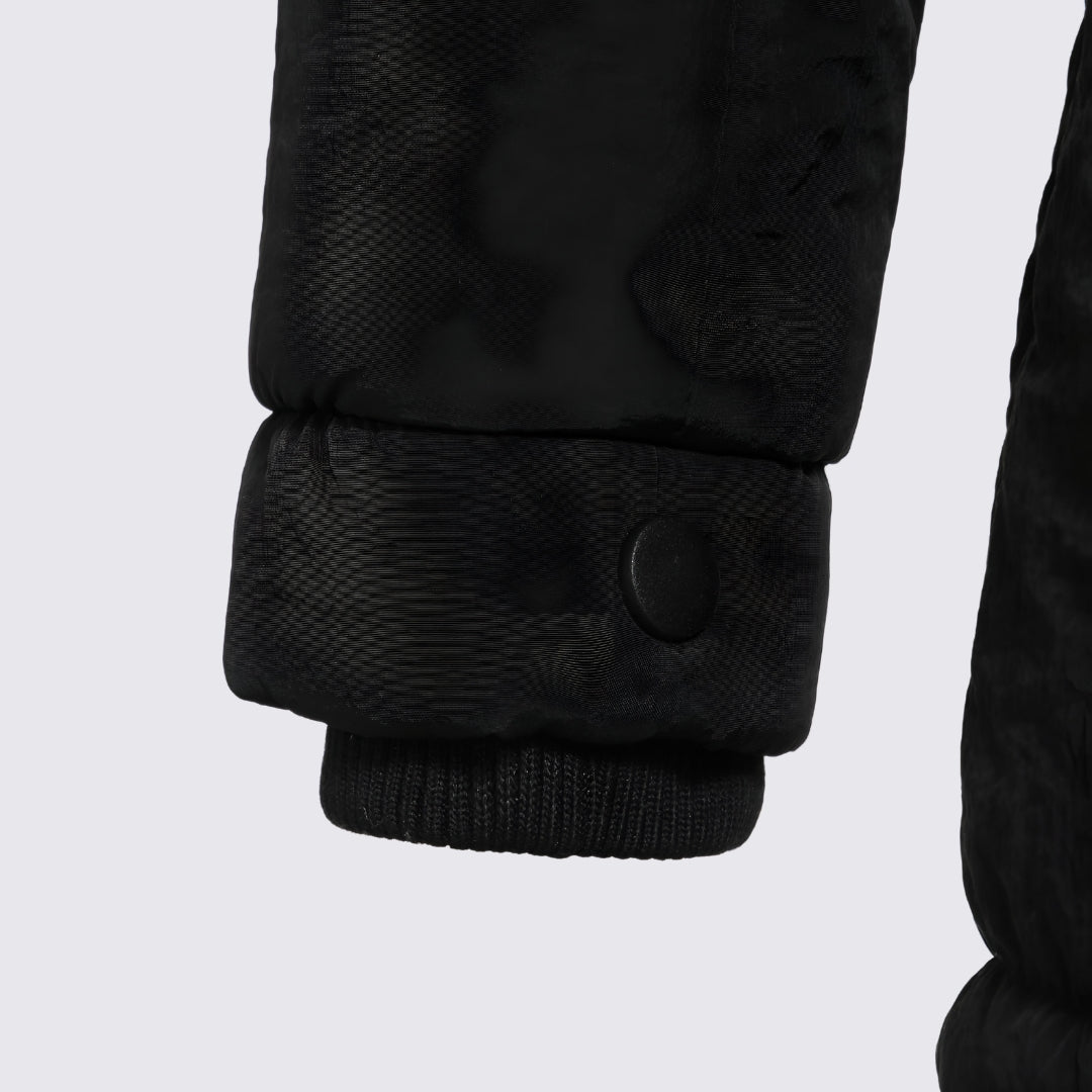 Close-up of the black parka sleeve cuff with snap tab and ribbed inner cuff