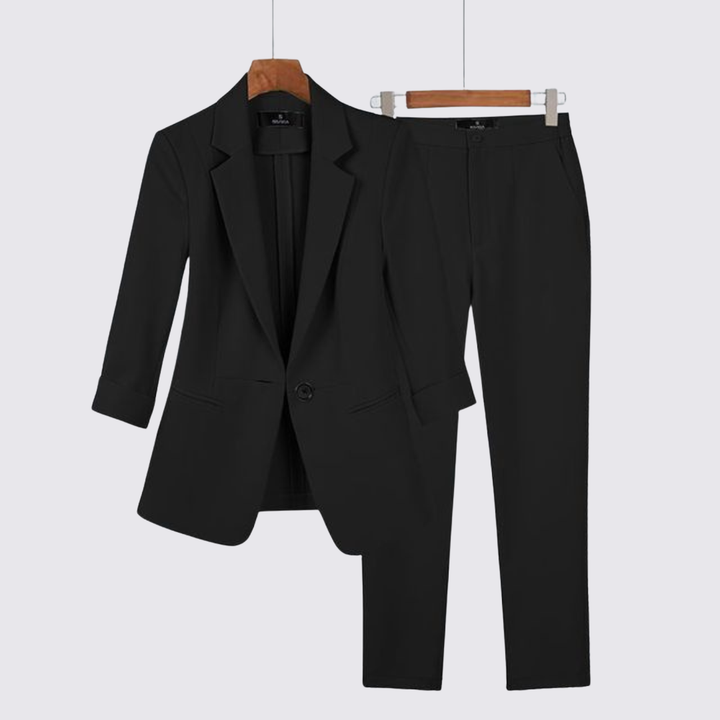 Black single button blazer and matching tapered trousers shown on hangers
