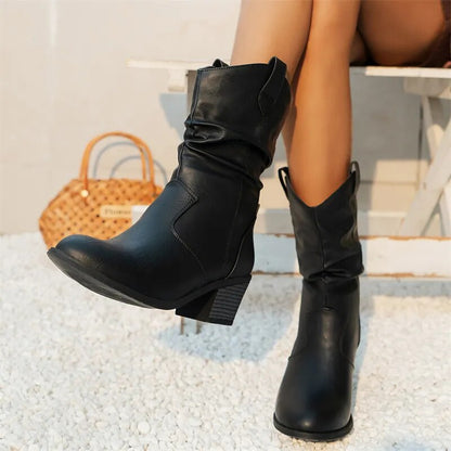 Black slouch western boots worn with one foot raised
