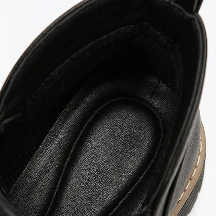 Close-up inside a black ankle boot showing the cushioned padded insole