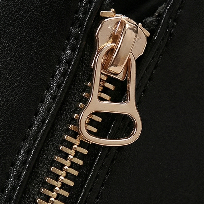 Close-up of the gold zip pull on the side of a black platform ankle boot