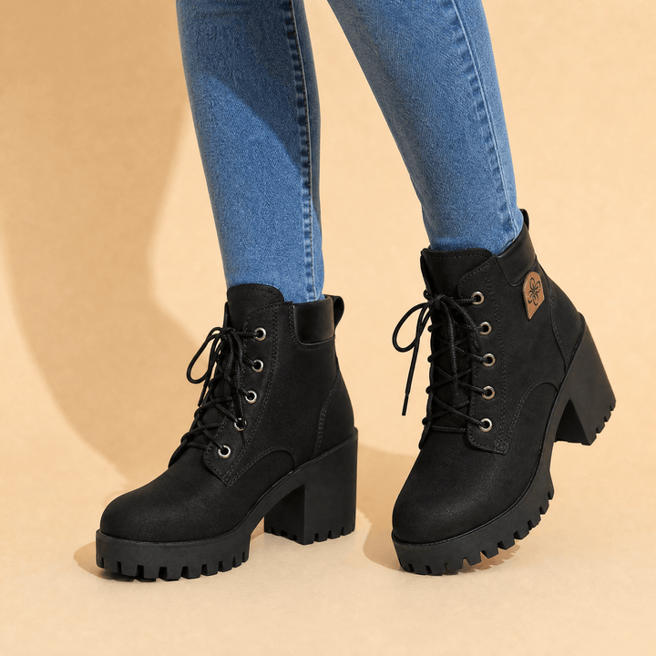Black lace up combat boots with chunky platform heels worn with blue jeans