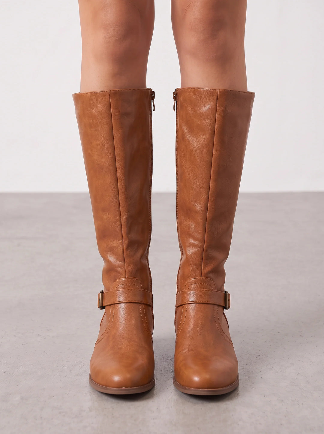 Tan leather riding boots seen from the front on bare legs