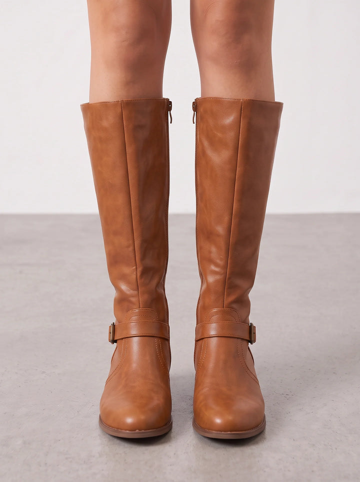 Tan leather riding boots seen from the front on bare legs
