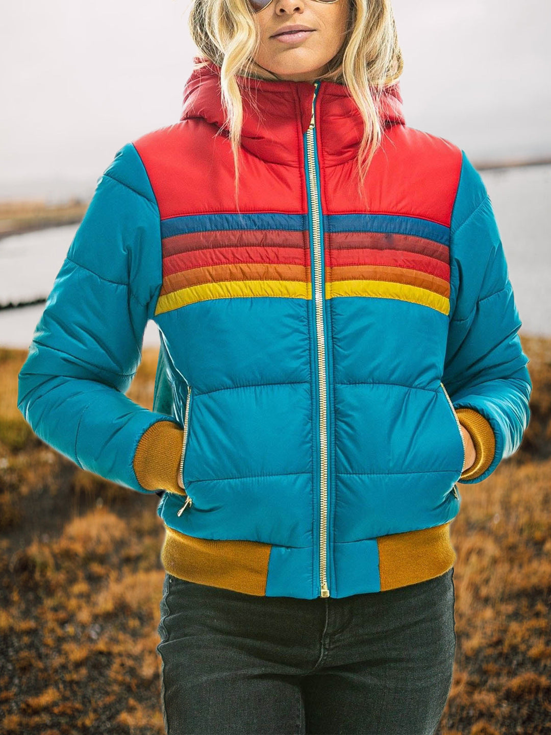 Teal hooded puffer jacket with a red yoke and retro rainbow chest stripes, zipped front