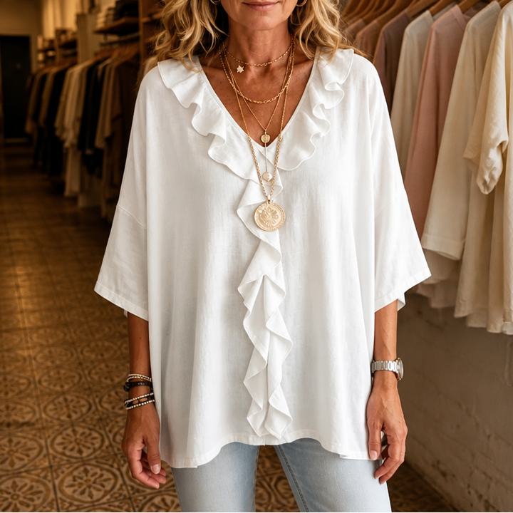 White V neck blouse with a ruffle front placket and elbow length sleeves