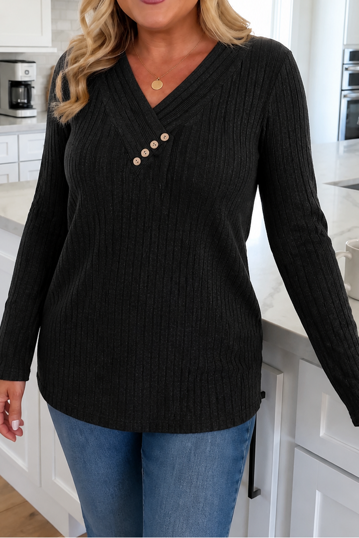Black ribbed knit top with a crossover V neckline and three wooden buttons, worn with jeans