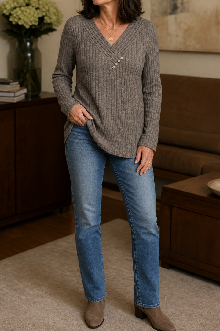 Woman wearing a taupe ribbed V neck button sweater with light blue jeans