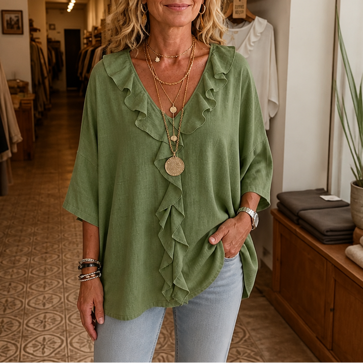 Sage green oversized blouse with ruffled V neck placket and half sleeves, front view