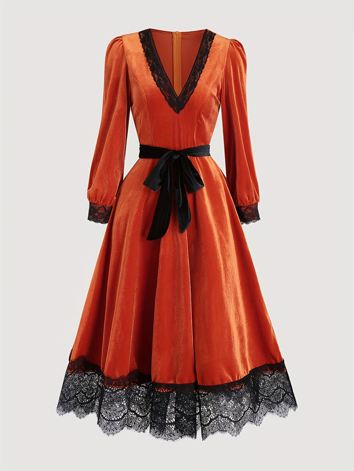 Orange velvet midi dress with V neck, black lace trim and tie belt on a plain background