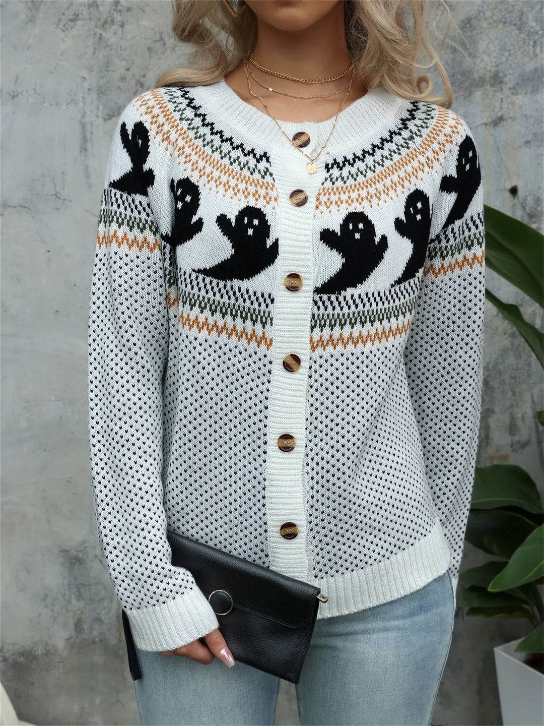White knit button cardigan with black ghost motifs across the yoke, front view
