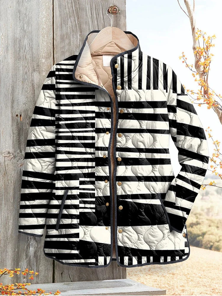 Black and cream striped quilted jacket hung on a wooden post