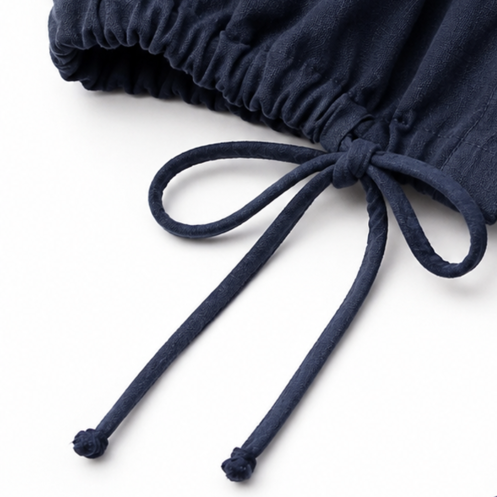 Knotted drawstring tie on the hem of a navy jacket