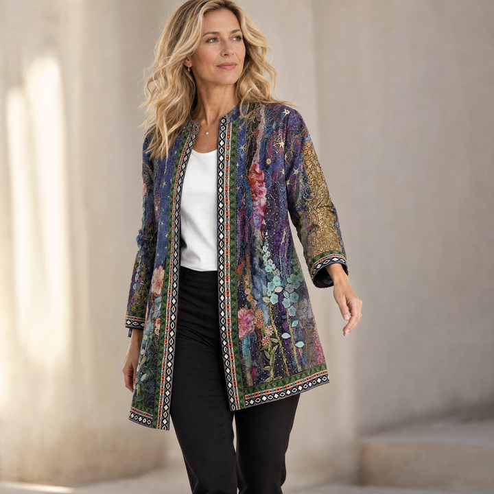 Woman in a sunlit hall in a purple floral print open jacket