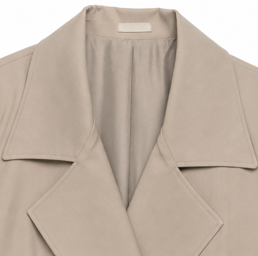 Close up of the notch lapel and storm flap on a taupe trench coat