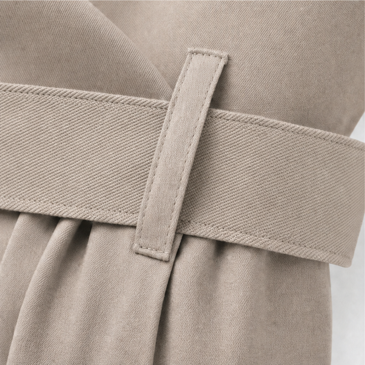 Belt and belt loop detail on a taupe trench coat
