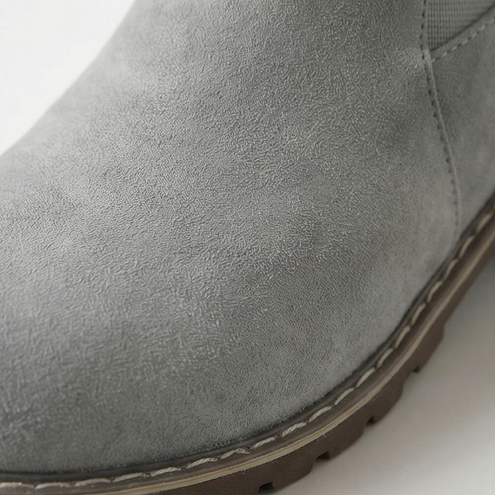 Woman at a cafe table wearing grey buckle strap booties