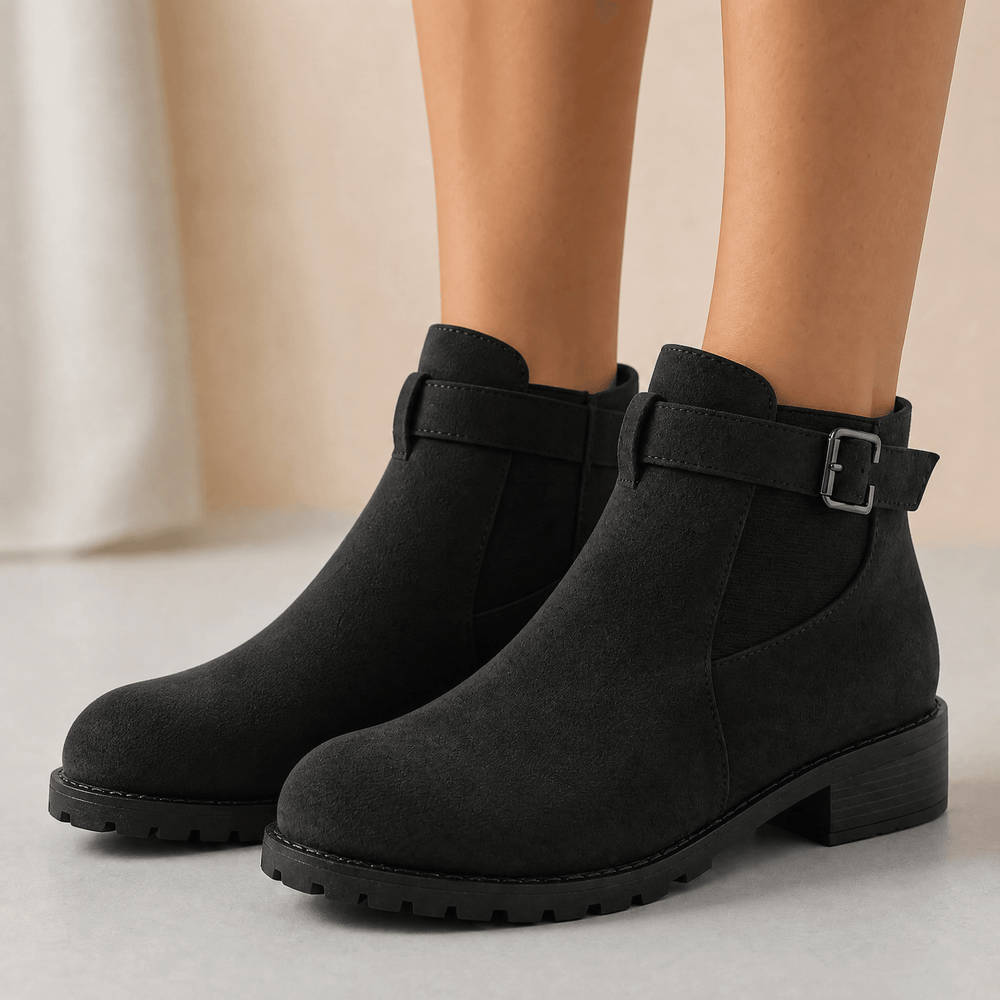Black suede ankle booties with buckle straps and lug soles