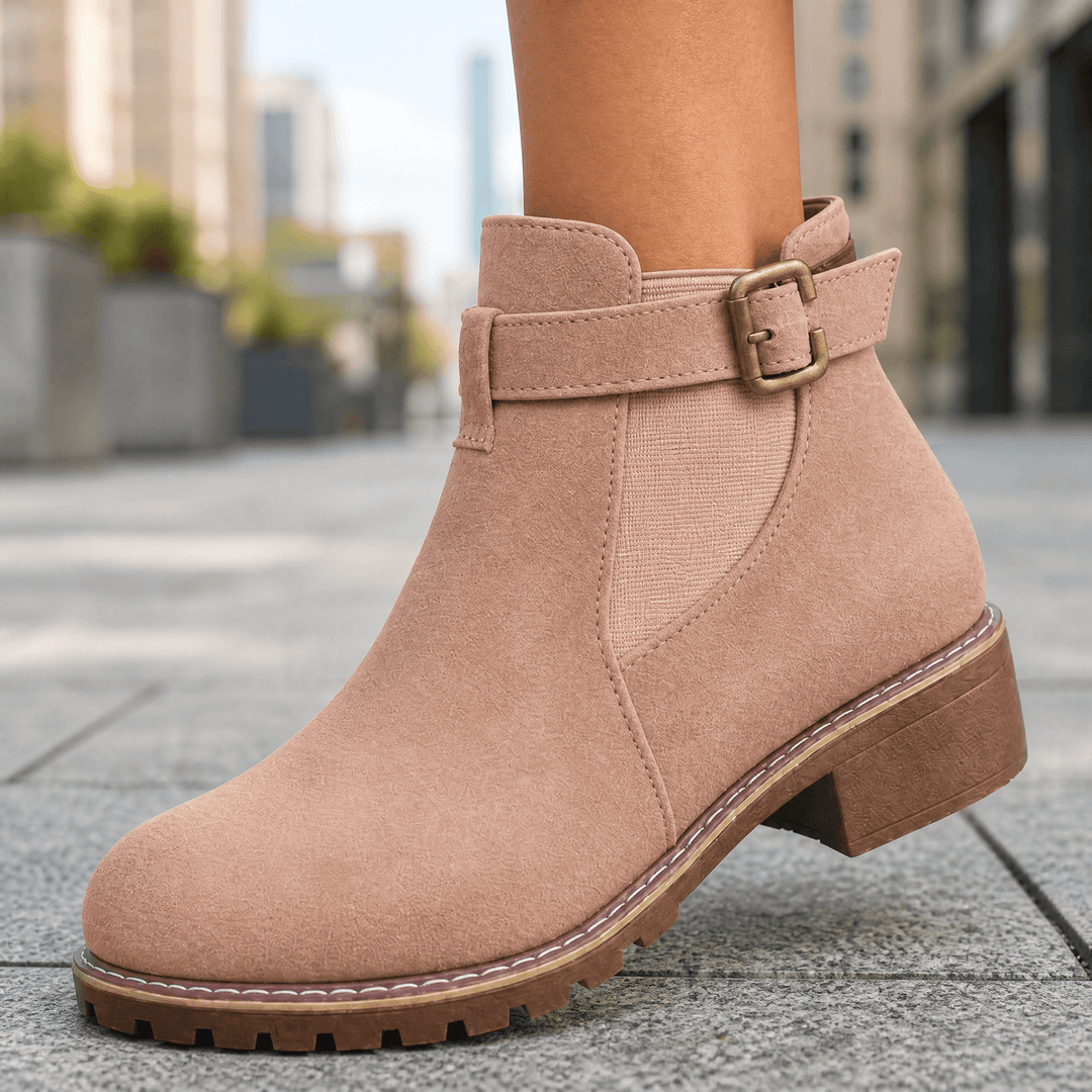Blush suede ankle boot with a buckle strap and a stacked block heel