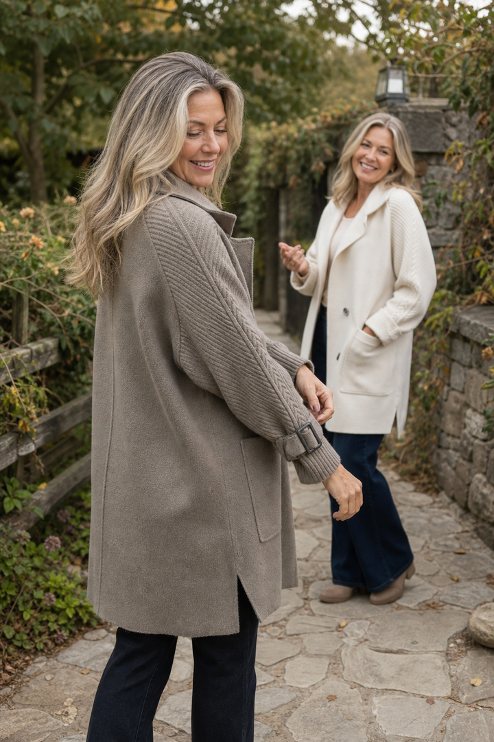 Two women outdoors in taupe and cream cable knit sleeve coats
