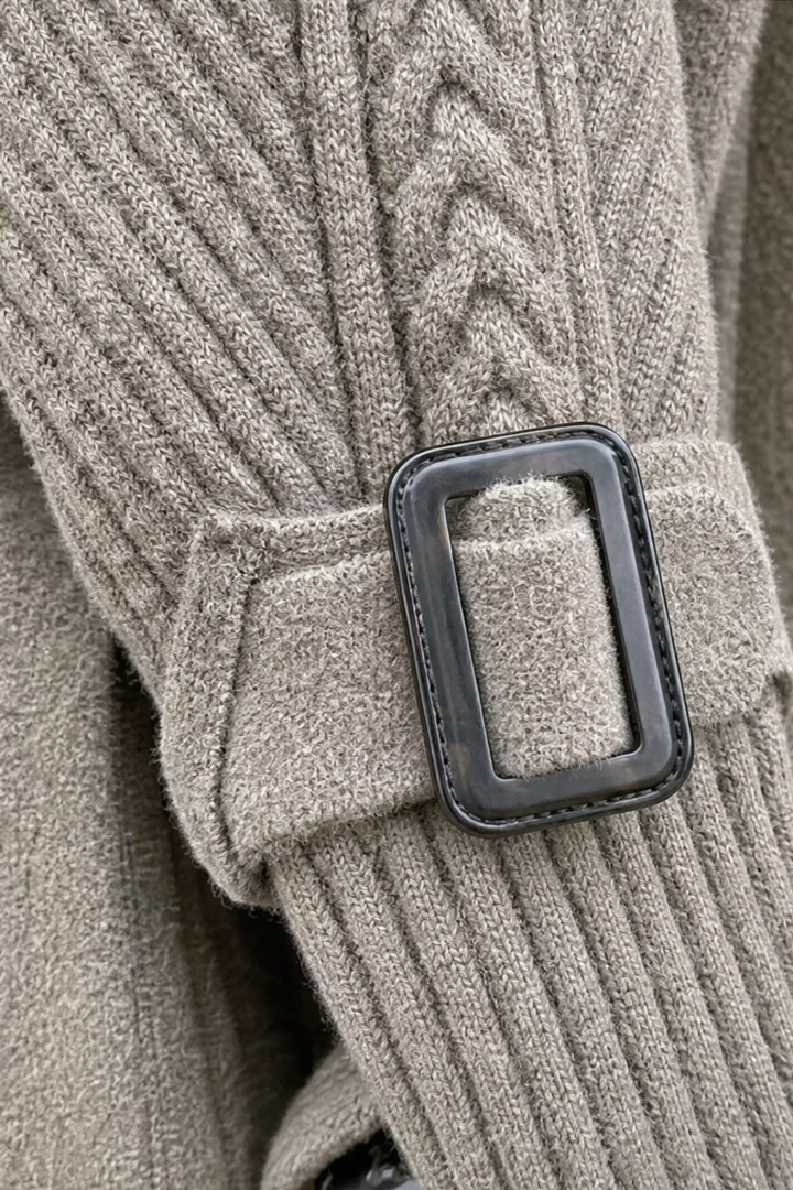 Buckle cuff detail on a cable knit coat sleeve