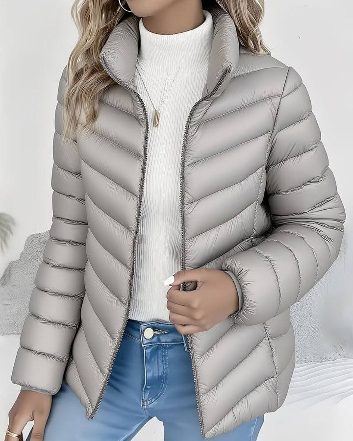 Light grey channel quilted jacket with a high zip collar