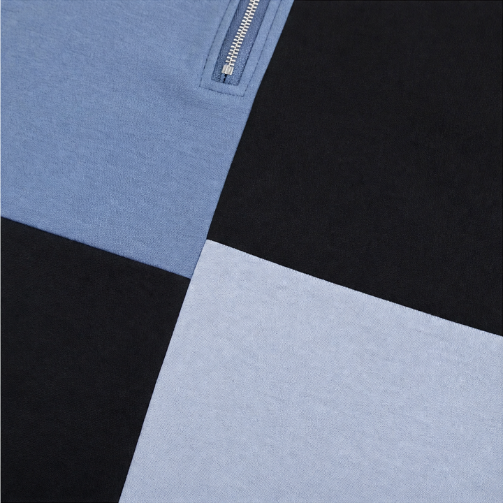 Close up of the colorblock seam where blue meets black on a sweatshirt