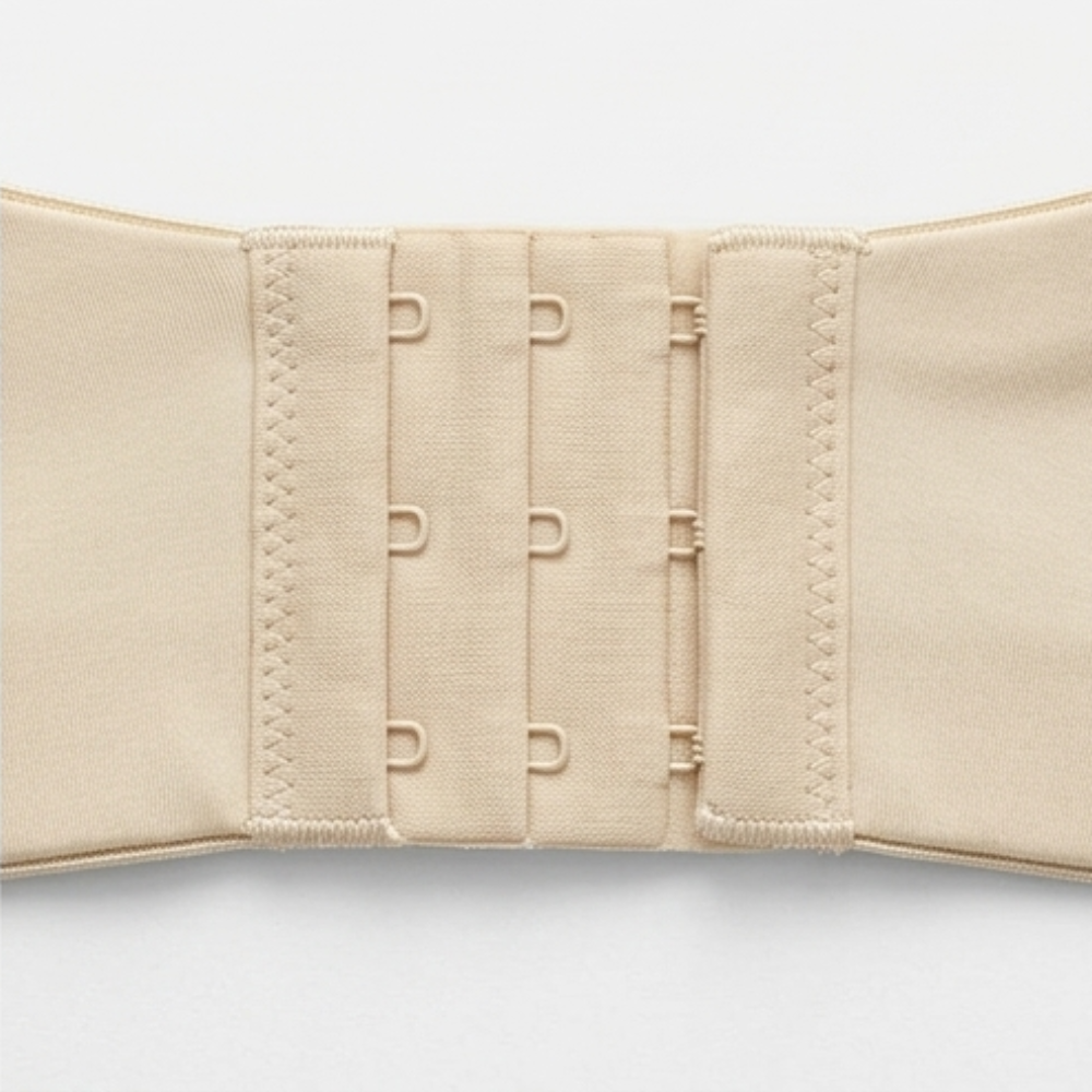 Close-up of the wide hook and eye band on a nude strapless bra