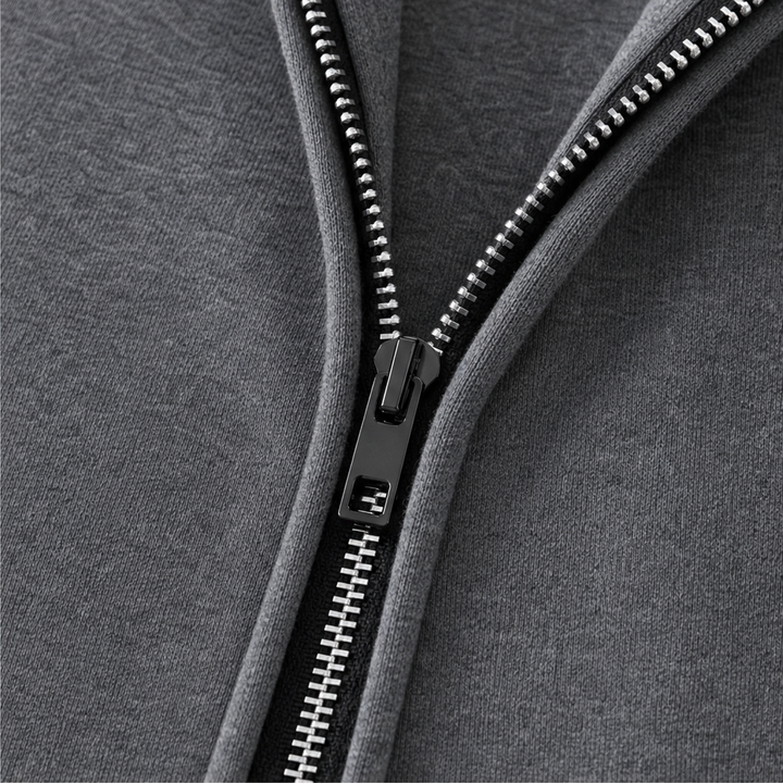 Metal zip detail on a grey hooded travel coat