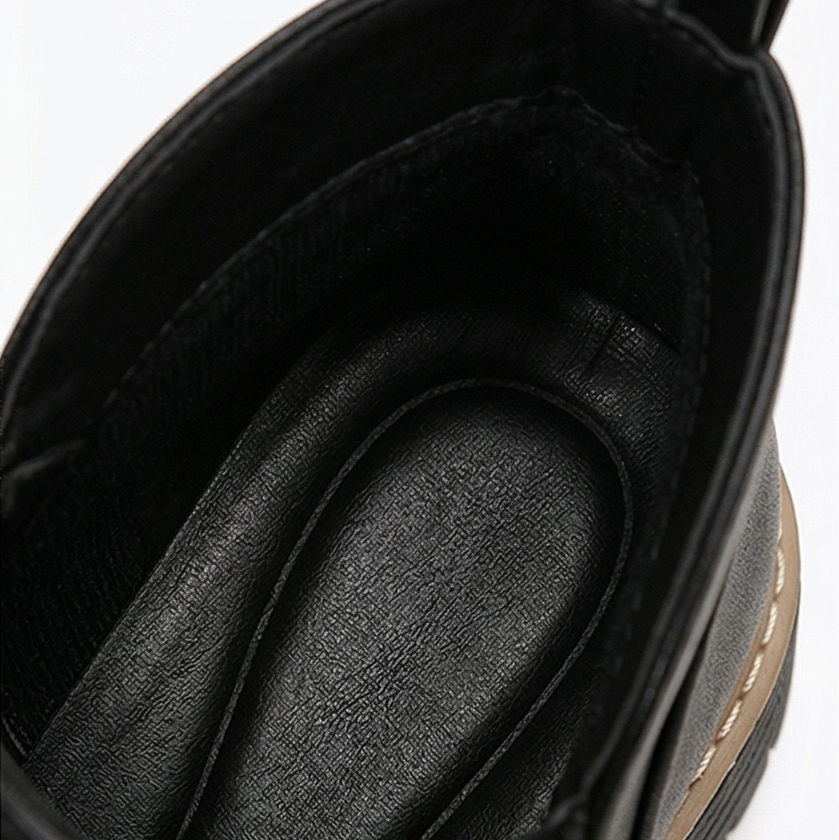 Close-up inside a black ankle boot showing the cushioned padded insole
