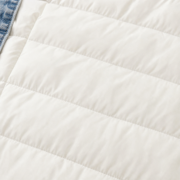 Close up of the horizontal quilting on a cream puffer jacket