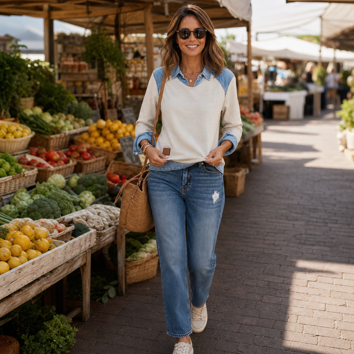 Woman walking through a market in a cream denim yoke sweatshirt