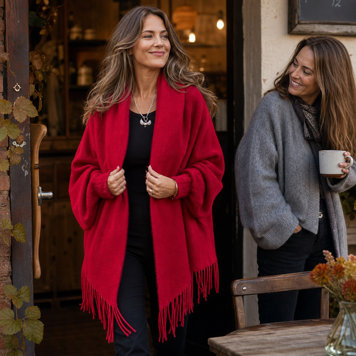 Two women outside a cafe, one in a red fringed shawl wrap