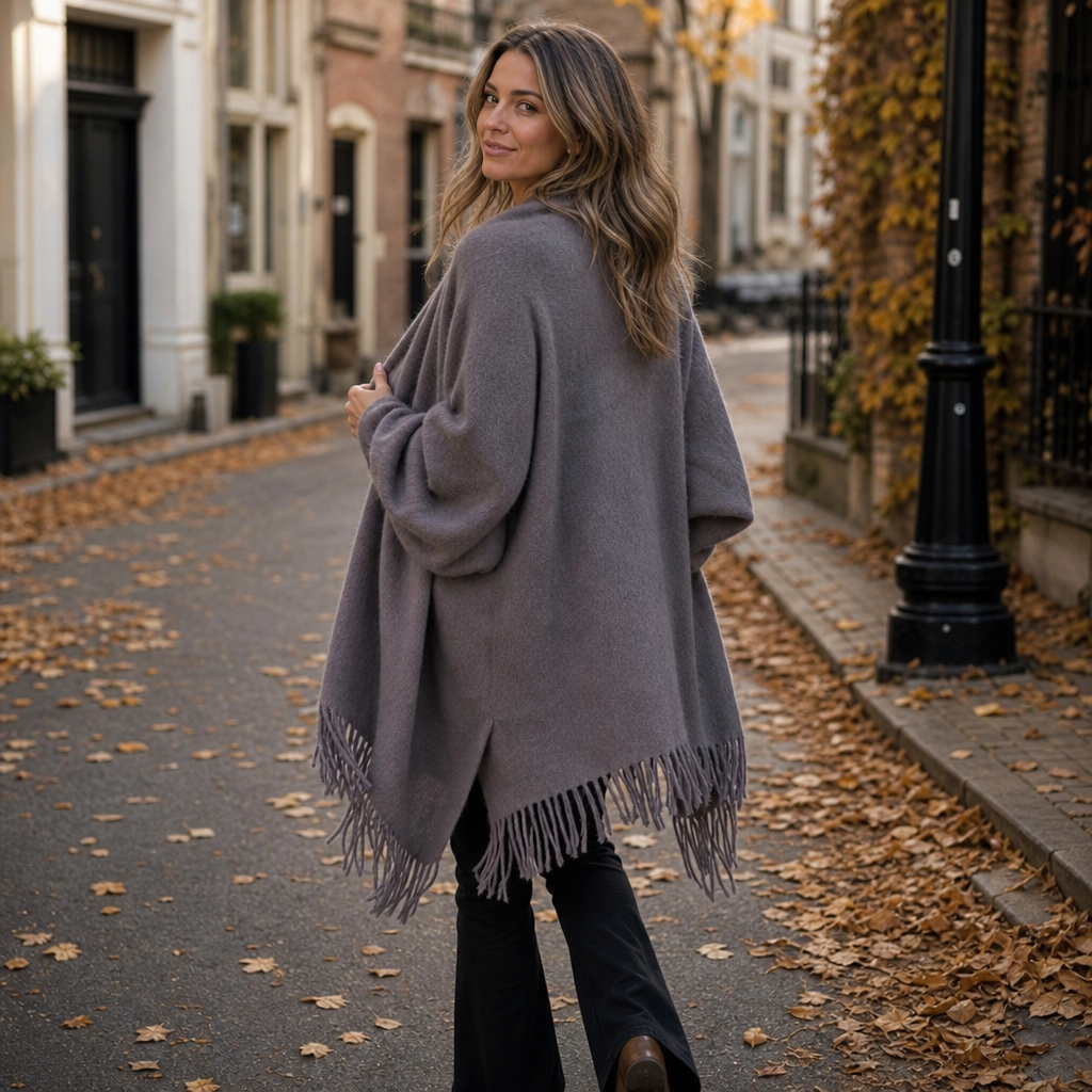 Back view of a grey fringed shawl wrap on an autumn street
