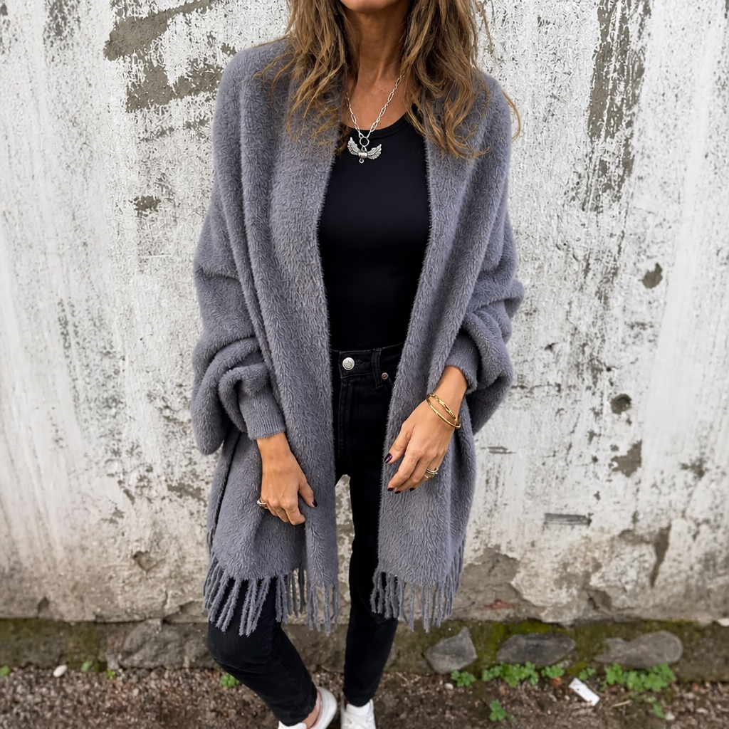 Grey draped shawl collar wrap with fringing and black jeans
