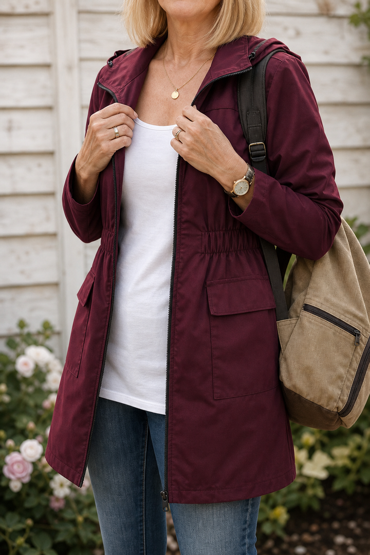 Burgundy hooded anorak worn open over a white top with jeans