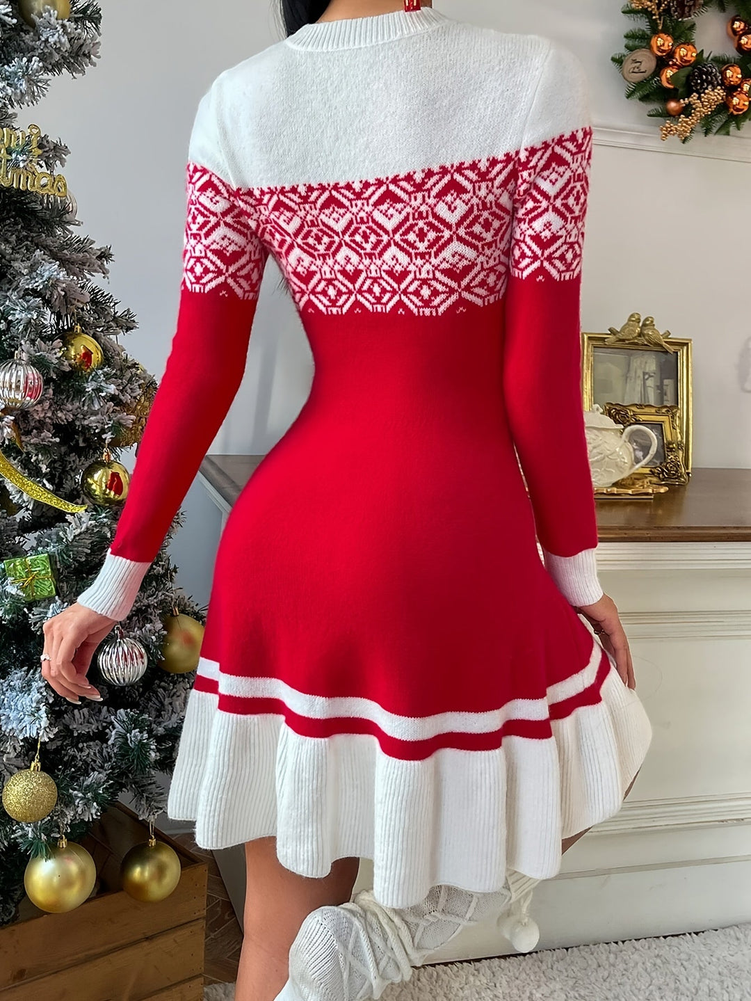 Woman in a red fair isle yoke knit dress beside a frosted Christmas tree