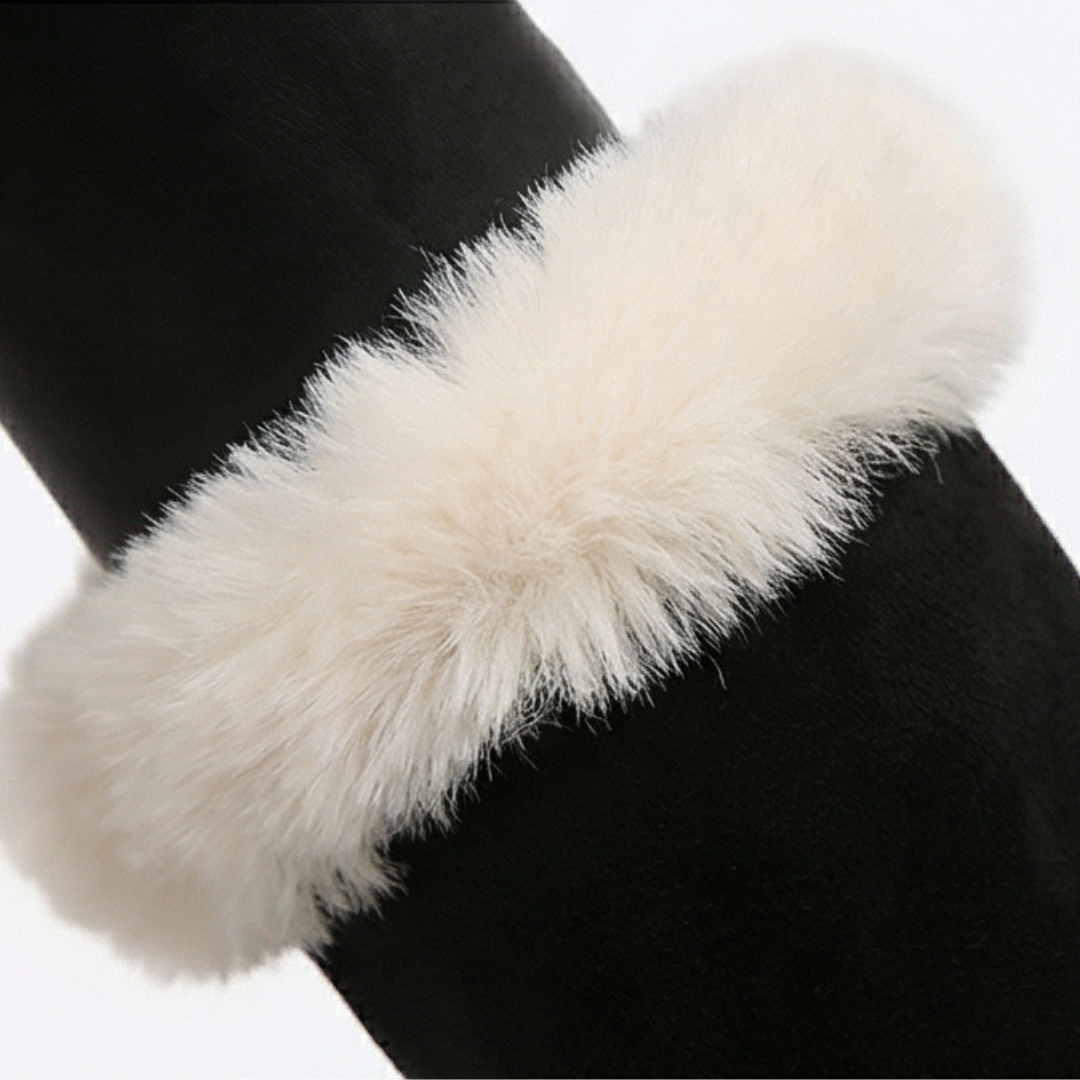 Close up of the cream faux fur cuff on a black suede boot