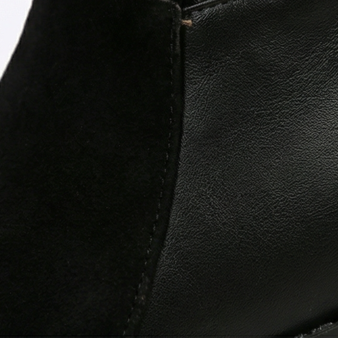Close up of the black suede and smooth panel on a knee high boot