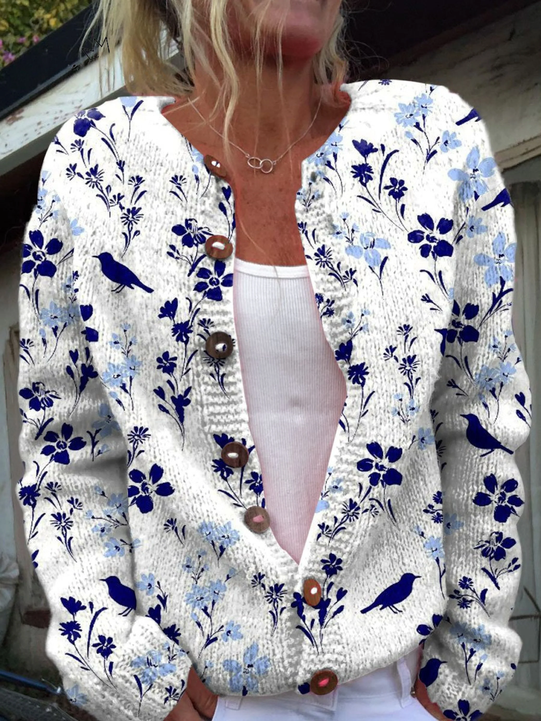 White knit cardigan with a blue floral and bird print and wooden buttons