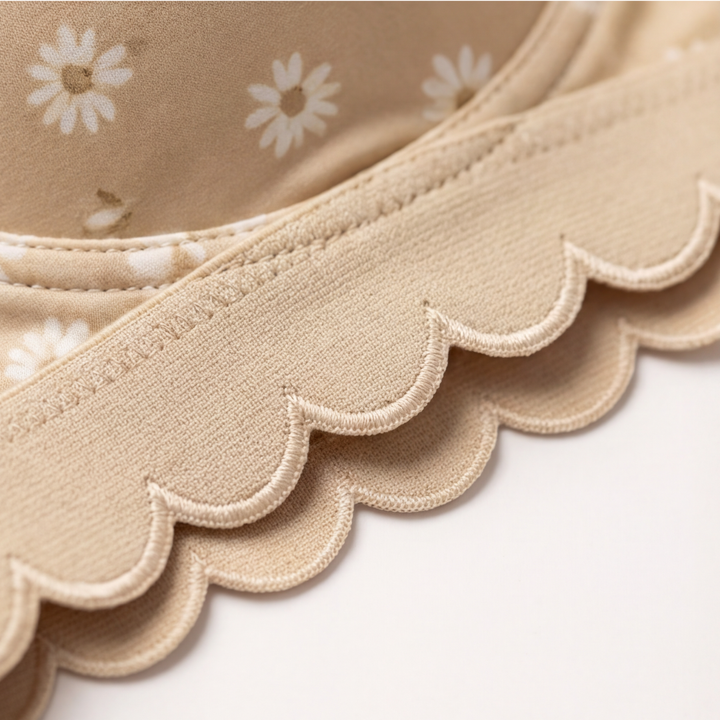 Scalloped edge along the band of a daisy print bra