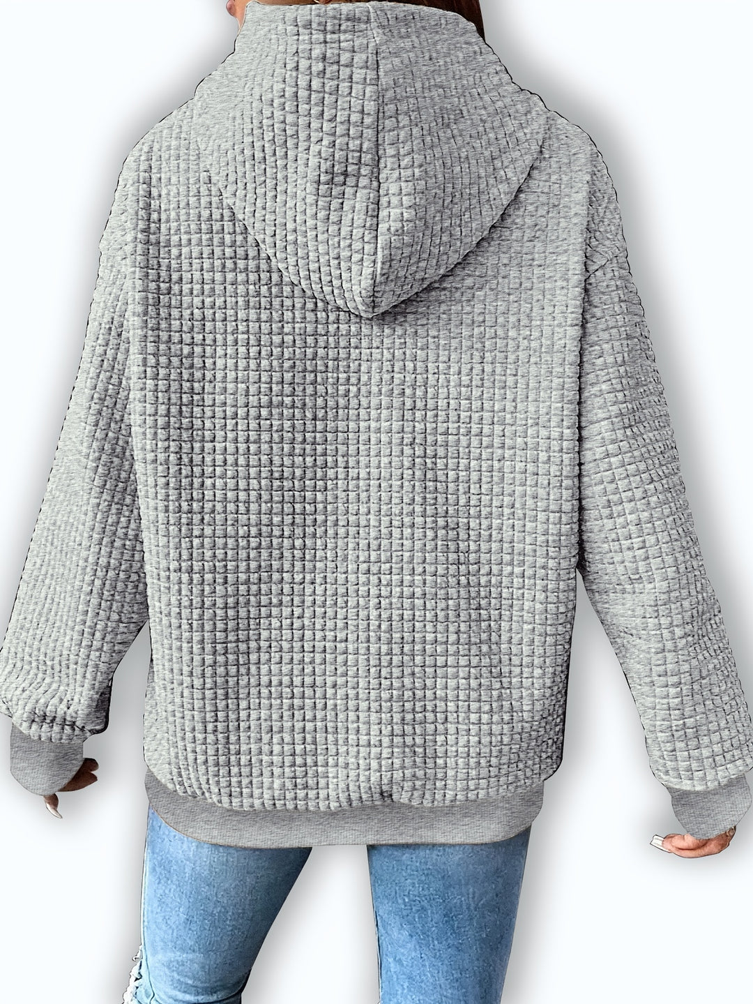 Back view of a light grey waffle textured hoodie with a relaxed fit and ribbed cuffs and hem