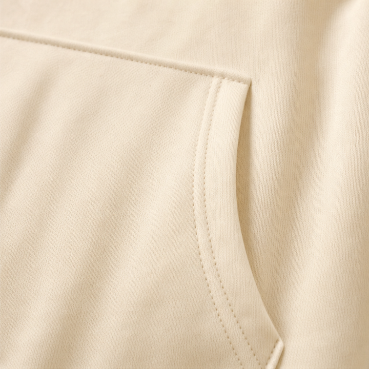 Close up of the kangaroo pocket stitching on a cream hoodie