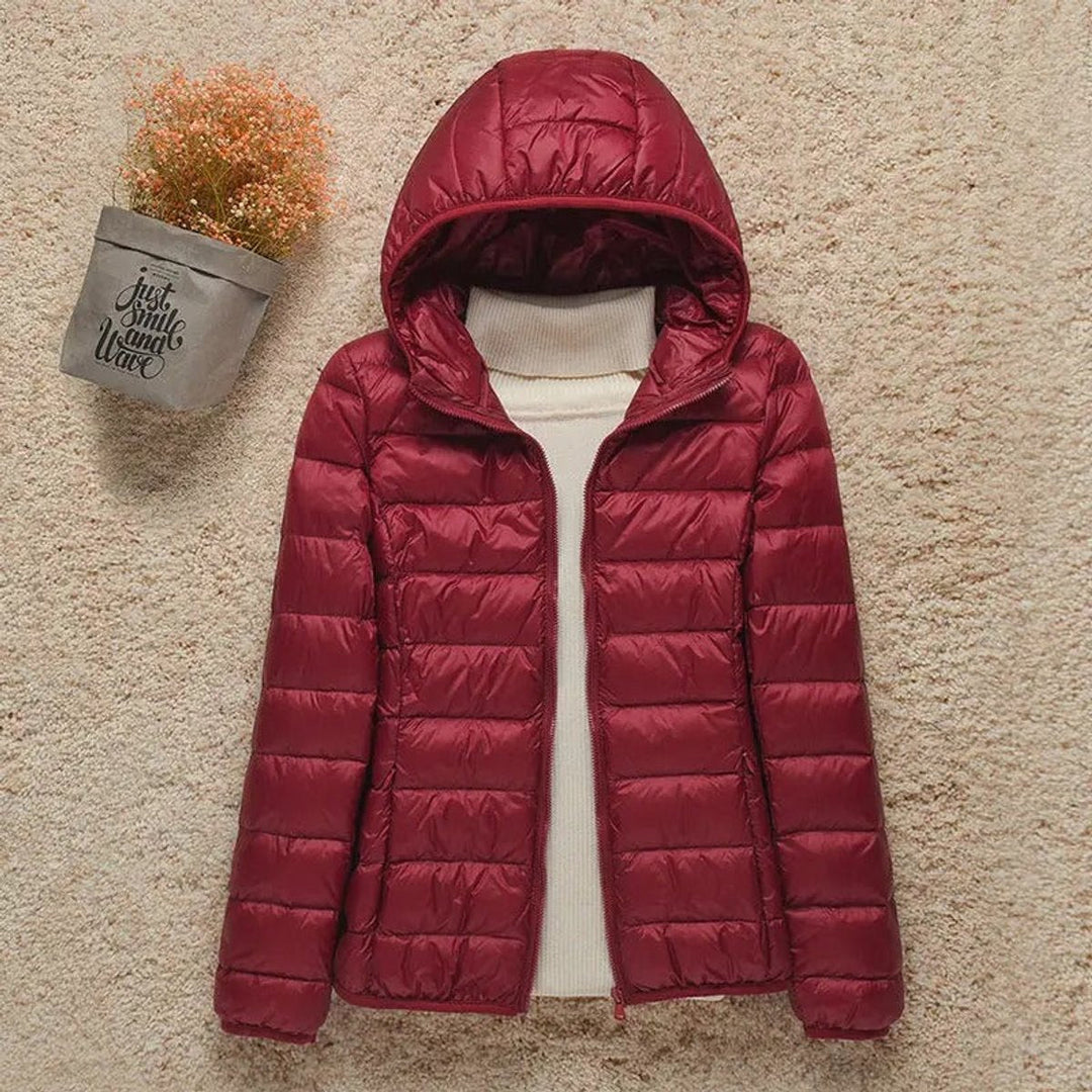 Burgundy hooded packable puffer jacket laid flat