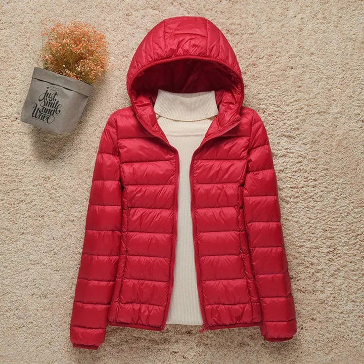 Red hooded packable puffer jacket laid flat